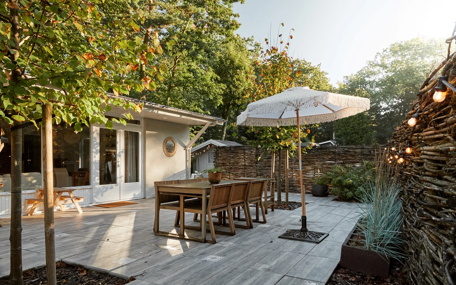 Boshutjemutje: terras met franjeparasol en tuintafel