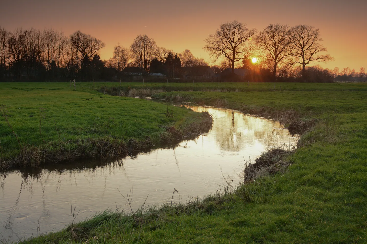 Het beekje het Merkske, de grens tussen Nederland en België, bij zonsondergang