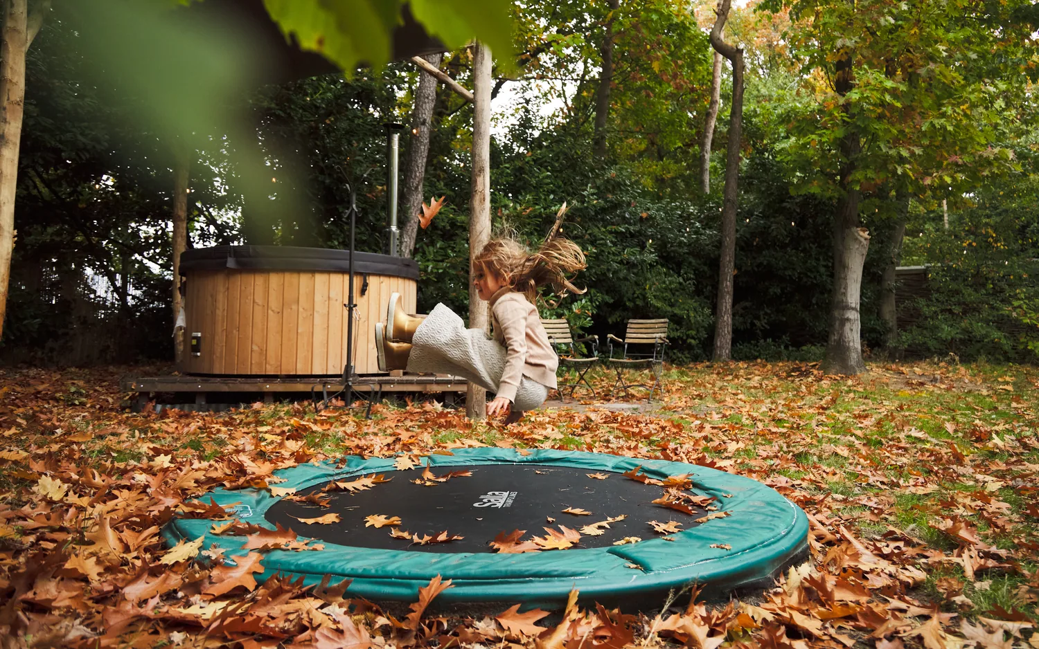 Springen op de trampoline tussen de herfstbladeren