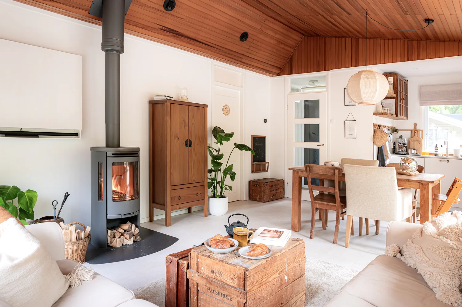 Woonkamer van Boshutjemutje met houtkachel en houten plafond